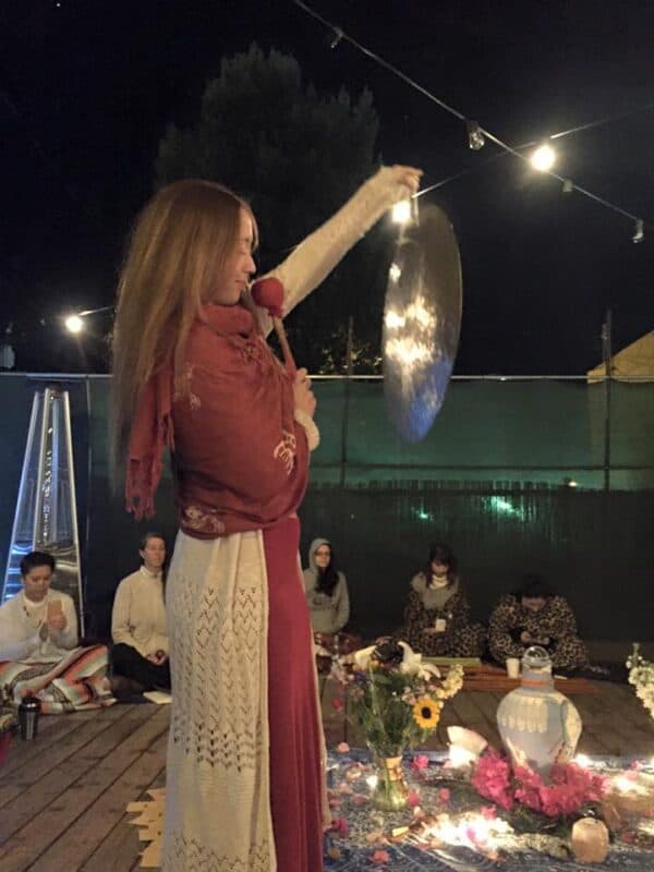 Sound Healer Joelle Nañawa plays her gong at the Goddess Moon Circle