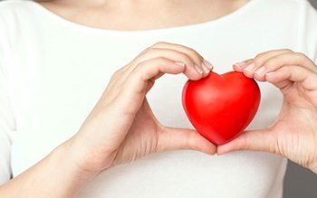 Image of woman holding red heart.