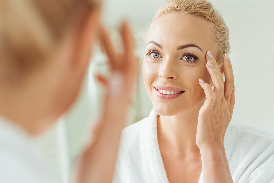 Woman Examining Skin Mirror